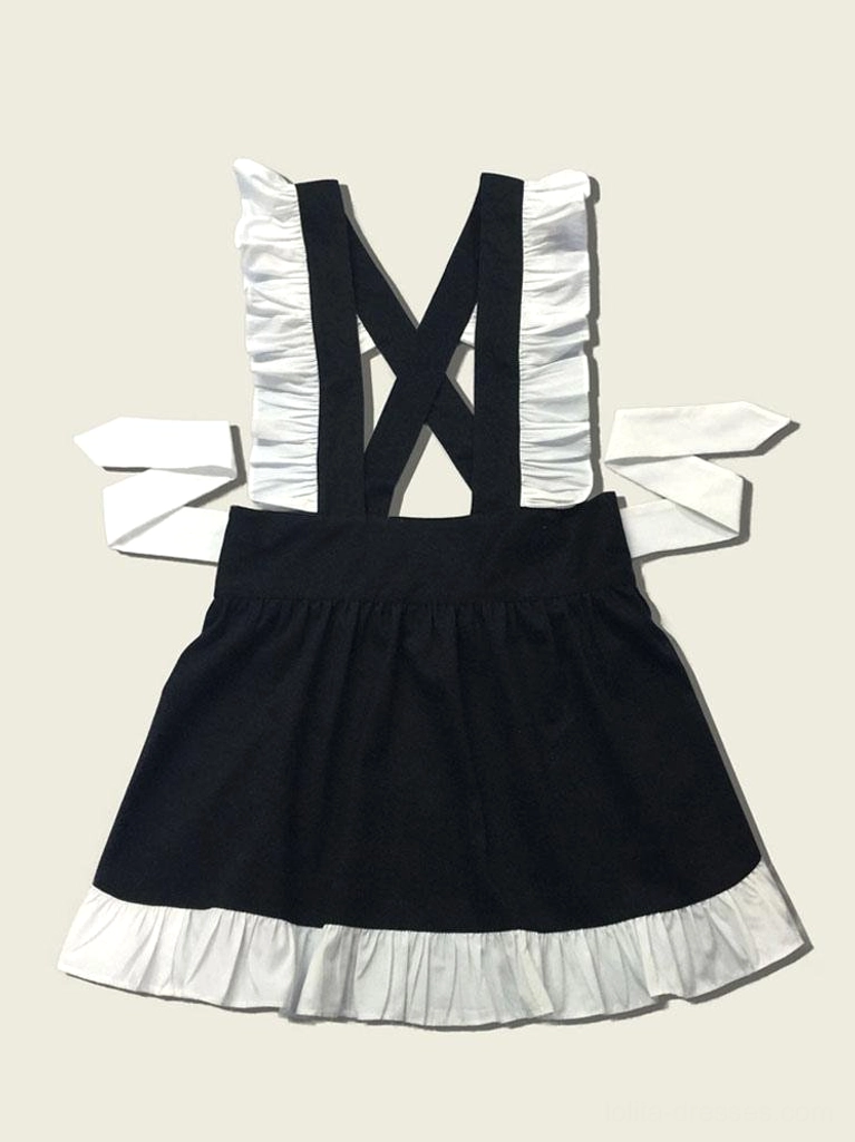 Black and white maid lolita apron flat lay showing cross straps with ruffled edges side ties and ruffled skirt hem