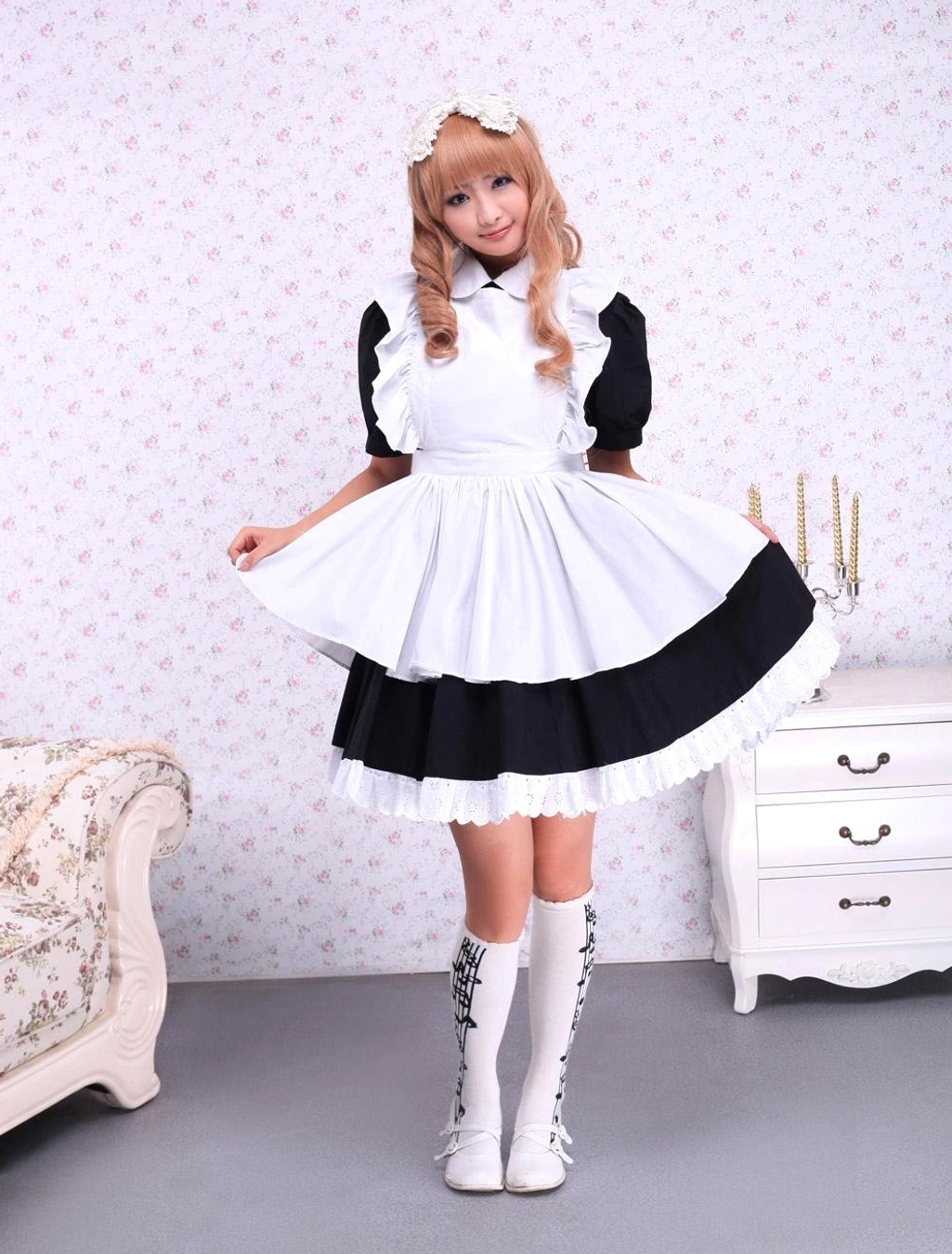 Side three-quarter view of maid lolita OP dress with flared white apron black lace hem white boots
