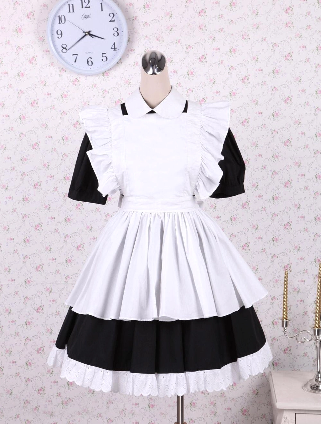 Mannequin display of black and white maid lolita OP dress with ruffled apron tiered lace hem vintage clock