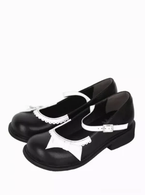 Black and white Mary Jane Lolita flats paired top three-quarter view showing white scalloped bow trim and round toe design on both shoes