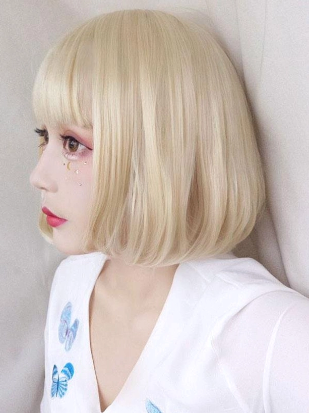 Blonde short bob lolita wig with blunt bangs straight smooth hair left side view close-up on model in white embroidered top