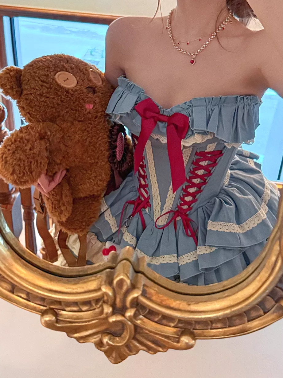 Detail shot of blue ballet lolita dress skirt featuring layered ruffles, tulle construction, red bow embellishments, and the characteristic volume of classic lolita silhouette
