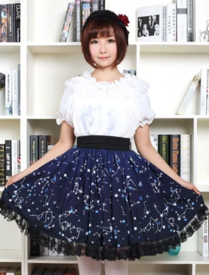 Blue constellation lolita skirt front three-quarter angle - model holding both sides to display voluminous a-line silhouette with high-waisted black elastic waistband