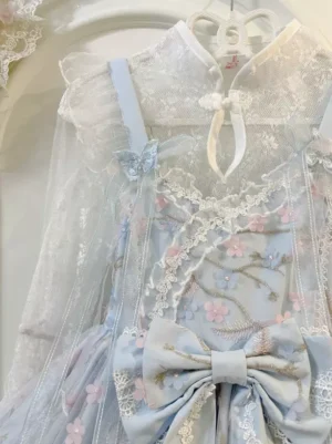 Close-up front view of light sky blue lolita dress showing mandarin collar lace overlay cherry blossom embroidery and large waist bow