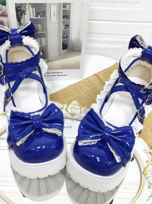 Pair of royal blue lolita chunky heel shoes with white platform sole and cross ankle straps featuring back heel bow detail over mirrored tray