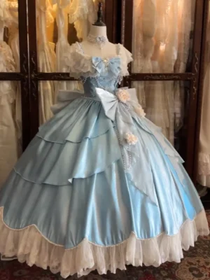 Blue lolita princess gown mannequin display showing square neckline with ruffle sleeves, multi-layered skirt construction with lace hem detail, bow and rose decorations for elegant bridal aesthetic