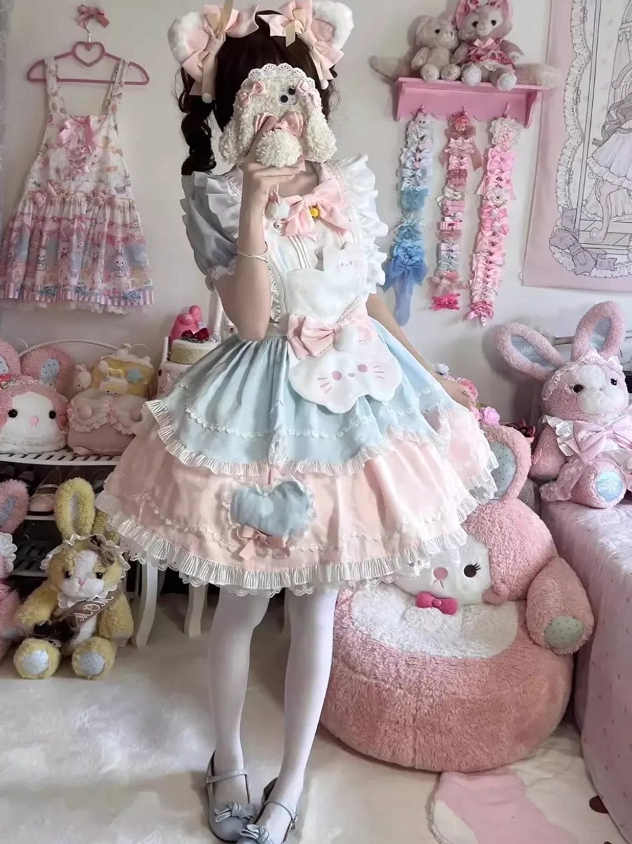 Blue and yellow color sweet lolita cat dress full body mirror view with large front bow, ruffled layered skirt, and cat face decoration on model with bunny ear accessories
