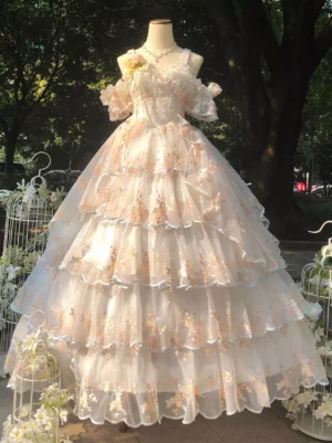 Blush pink sweet lolita wedding dress front view with off-shoulder ruffled sleeves, multi-tiered floral embroidery skirt, and tiered tulle construction in outdoor garden setting