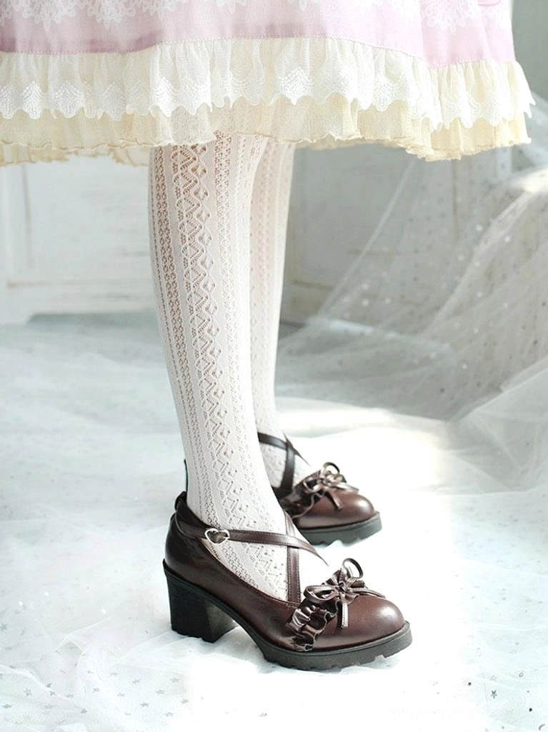 Brown Lolita block heel shoes full lower body front view, model wearing patterned white tights and frilly dress, soft indoor studio background showcasing cross strap ruffle design