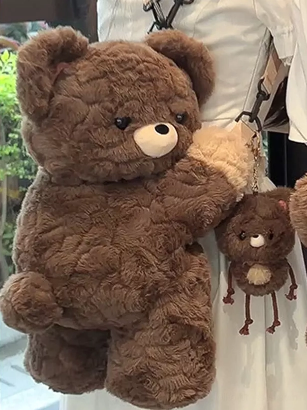 Large teddy bear plush bag in dark brown quilted corduroy with beige palm and white nose accents, featuring adorable matching mini teddy bear plush charm attachment