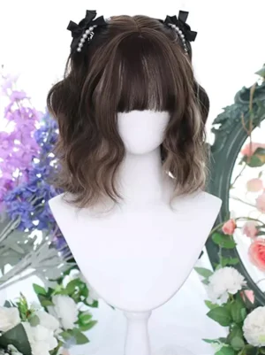Two-tone brown heat-resistant lolita wig featuring short wavy bob cut with blunt bangs, accessorized with black bow and pearl hairpins on mannequin with floral backdrop for sweet lolita style inspiration
