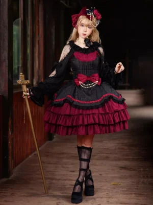 Burgundy and black gothic lolita jumper dress with velvet bows full front view, featuring color block design, ruffled layered skirt, and classic lolita silhouette worn by model in vintage corridor
