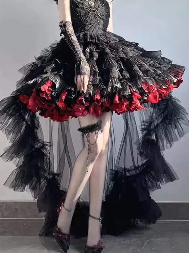 Black and burgundy gothic lolita high-low dress with ruffled tulle train detail and red floral hem trims worn by model in front view