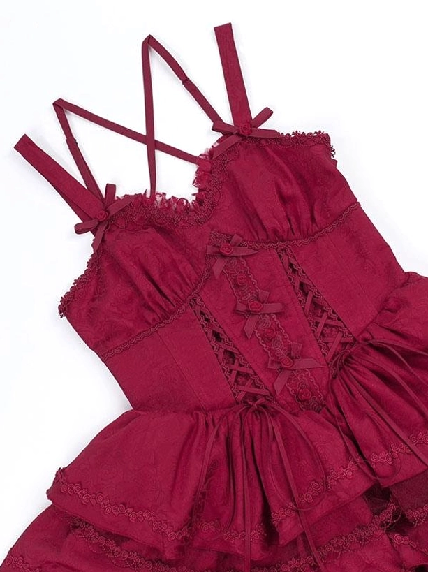 Burgundy gothic lolita dress bodice close-up detail red background crisscross camisole straps lace-up front ruffled fabric embellishments
