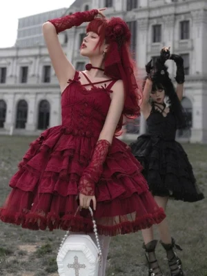 Burgundy gothic lolita ballet dress three-quarter front view cross camisole straps ruffled tiered skirt cross-themed handbag outdoor vintage architecture