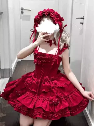 Burgundy Gothic Lolita jumper dress front view with ruffled straps, rose decorations, and matching bonnet on model