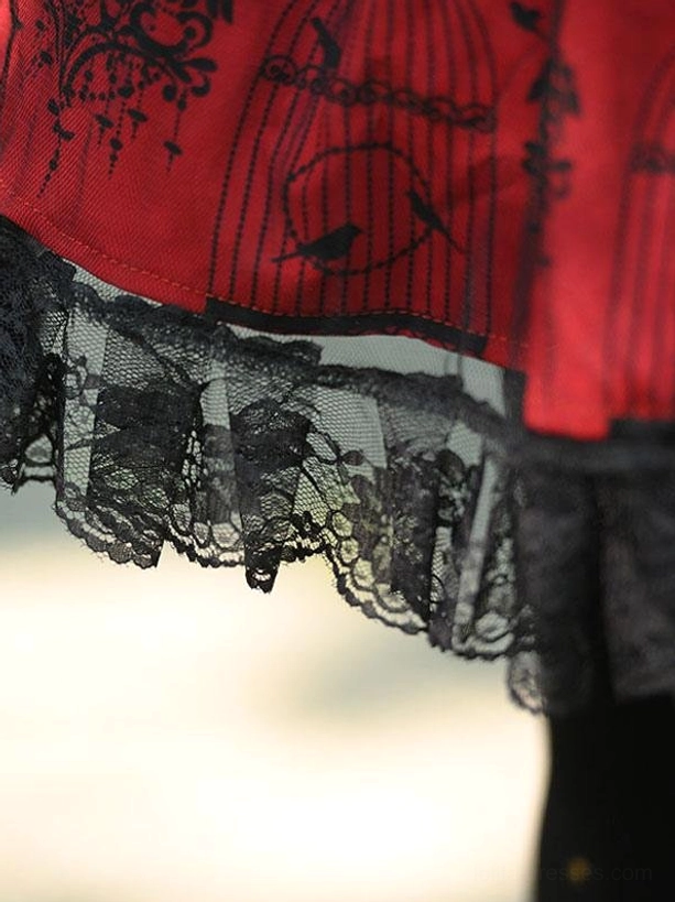 Burgundy gothic lolita skirt hem side view showing layered black lace ruffled trim red fabric with black vintage prints