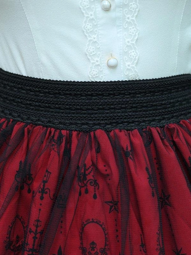 Burgundy gothic lolita skirt waist smocking close up flat lay showing black smocked elastic waist white lace blouse with pearl buttons