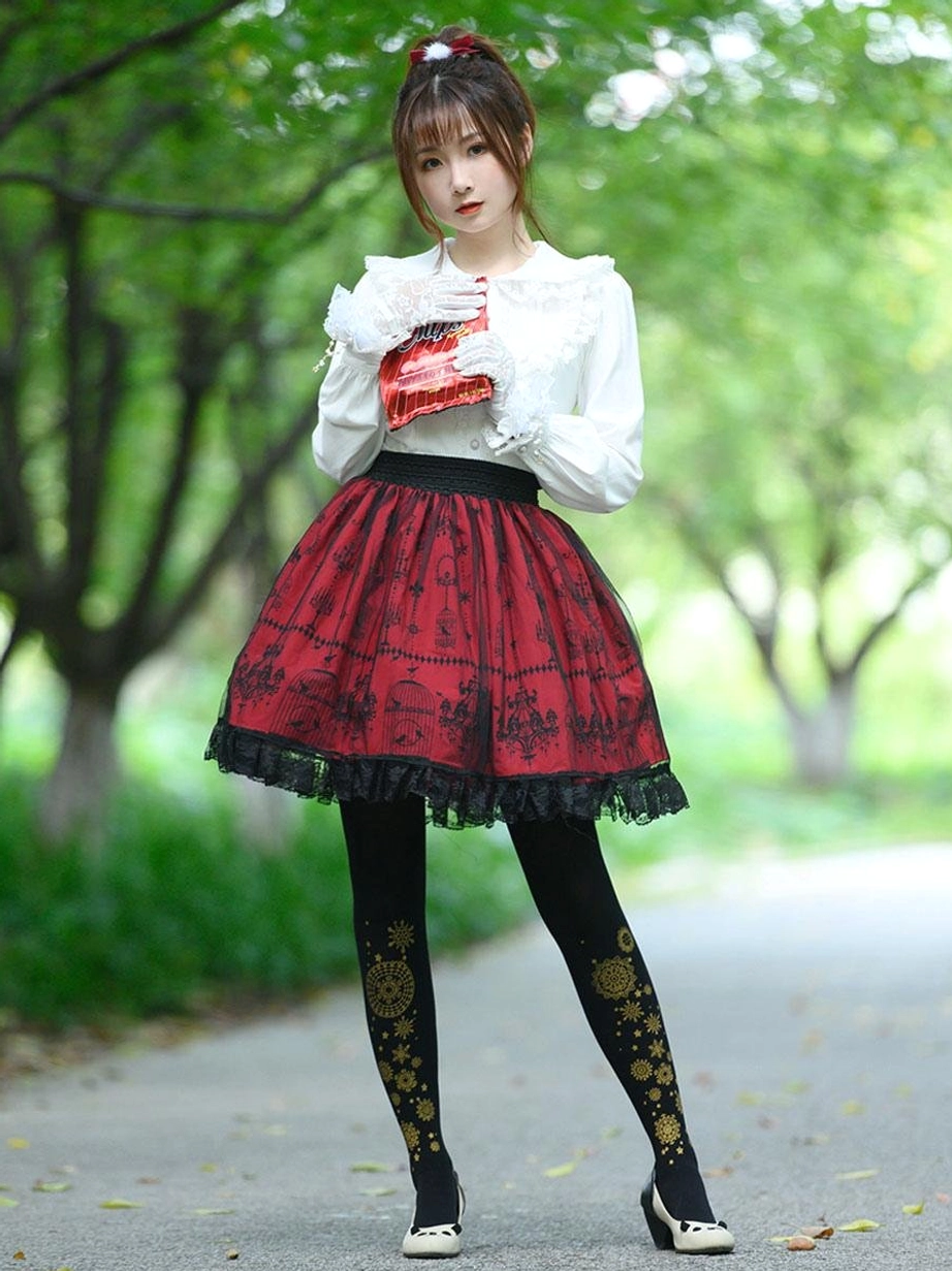 Burgundy gothic lolita skirt with vintage black prints full body front view on model in park setting wearing lace gloves and red clutch