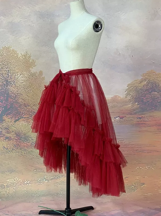 Burgundy high-low lolita skirt with sheer tulle layers and detachable train shown in side front view with tie waist closure on dress form