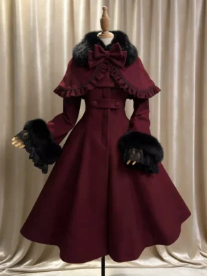Burgundy Gothic Lolita wool winter overcoat with waist belt and detachable ruffled cape, full front view with beige curtain backdrop