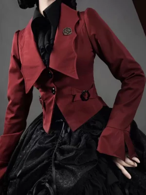 Burgundy Gothic Ouji Lolita coat close-up side partial view featuring wide lapel, flared cuffs, black buttons and waist buckle embellishment, layered with black inner shirt and black ruffled skirt