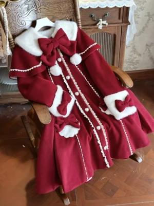 Burgundy lolita cloak overcoat side overhead view displayed on wooden chair showing furry collar, bow ornaments, and fur-trimmed cuffs