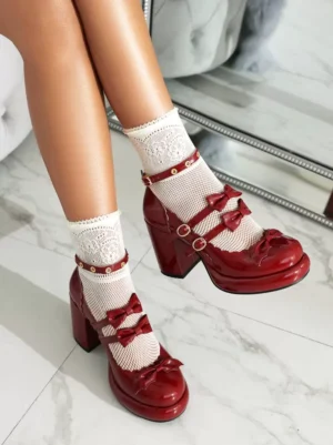 Burgundy Lolita Mary Jane platform shoes with metal buckle straps and bow trims, worn with white lace crew socks, overhead front view