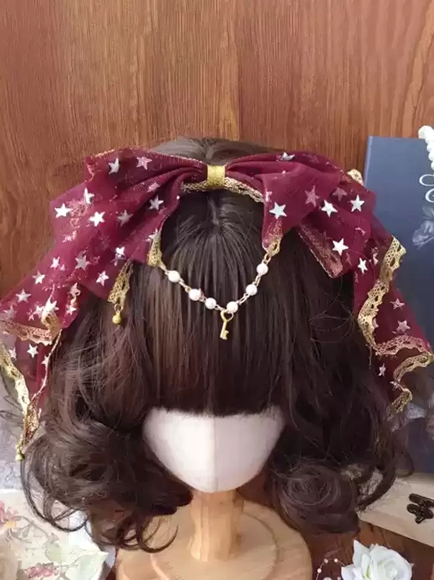 Burgundy maroon star mesh lolita bow headwear with gold lace border and pearl drop chain on brown wig mannequin