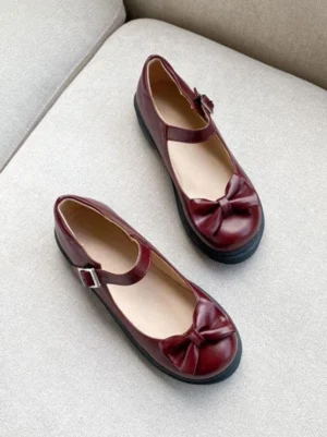 Burgundy Mary Jane Lolita flat pumps with signature bow embellishment and ankle strap - overhead flat lay photography