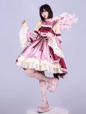 Burgundy Qi-style Lolita dress front view with halter neck, two-tone color block, ruffled trims and large waist bow on model with cherry blossom props