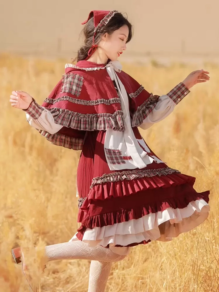 Burgundy Little Red Riding Hood Classic Lolita Dress with hooded cape and plaid accents - side dynamic angle in wheat field - burgundy off-white color scheme with ruffled layered hem