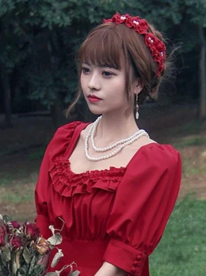 Burgundy ruffled lolita headdress hairband with pearl jewelry details worn by model in red vintage lolita dress outdoors woodland setting