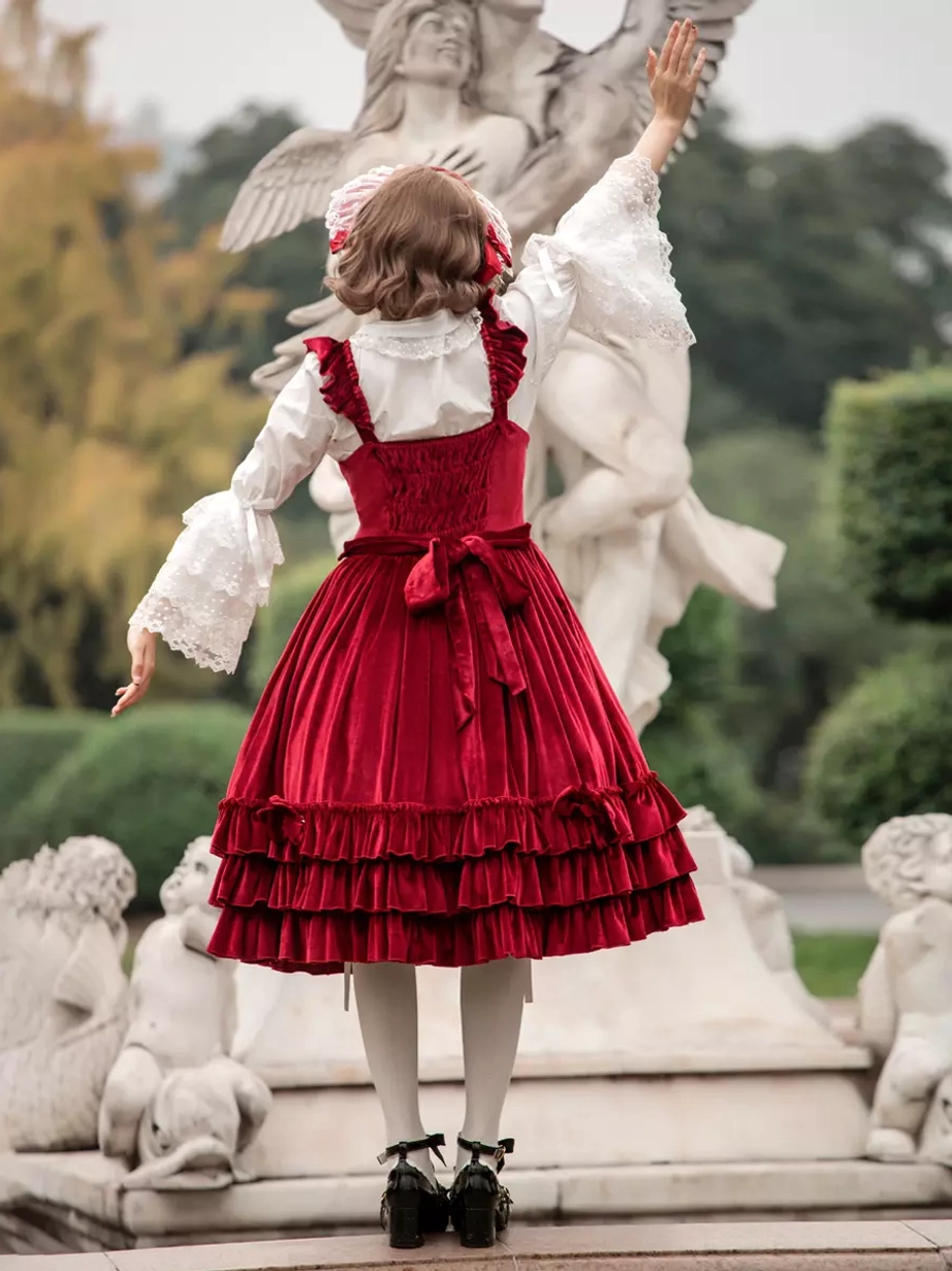 Burgundy sweet lolita JSK dress back view with ruffled skirt hem and waist sash detail, paired with white lace-trimmed inner blouse