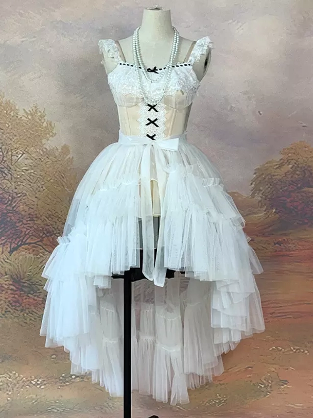 White tiered high-low tulle skirt set with burgundy train accessory and waist bow detail displayed on dress form with pearl necklace