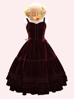 Burgundy red velvet sweet lolita jsk dress with lace-up bodice, sweetheart neckline, and tiered ruffled skirt displayed on mannequin with flower wreath against pink background