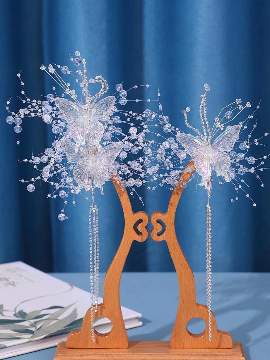 Pair of butterfly hairpins front display on wooden stand with blue background showing double butterfly per set crystal beaded branches and tassel pendants