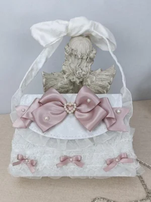 Pink cameo lolita bow handbag front view with bow-shaped handle lace ruffles pearl heart hardware small pink accent bows