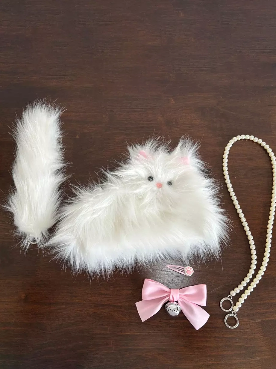 Disassembled Lolita cat bag components flat lay on dark wood including main bag, detachable tail, pearl chain strap, and bonus paw hair clip accessories