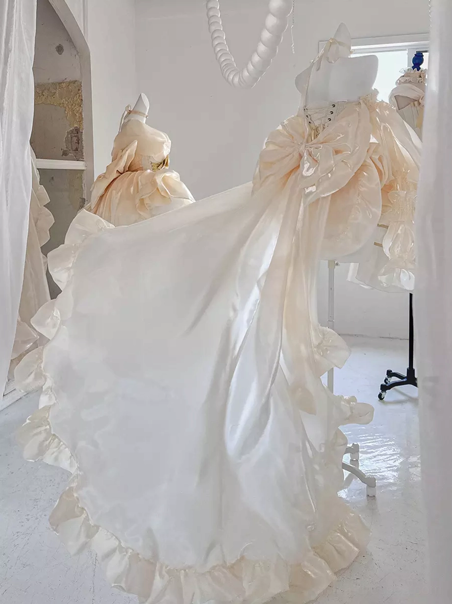 Champagne ballet lolita dress detail shot showcasing ruffled layers, bow embellishments, strapless corset construction, and fabric texture