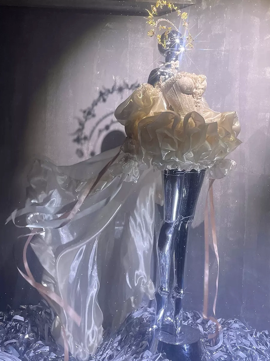Champagne ballet themed lolita formal gown with sheer flowing train, short ruffled skirt, and gold halo headpiece accent, side profile view