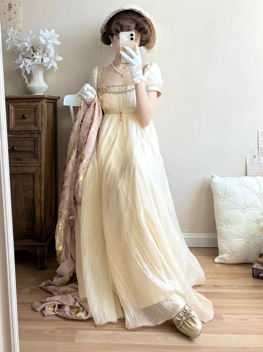 Light gold Regency Lolita evening gown showing champagne tone fabric, short puff sleeves, empire waist with chain details, romantic sweet Lolita aesthetic