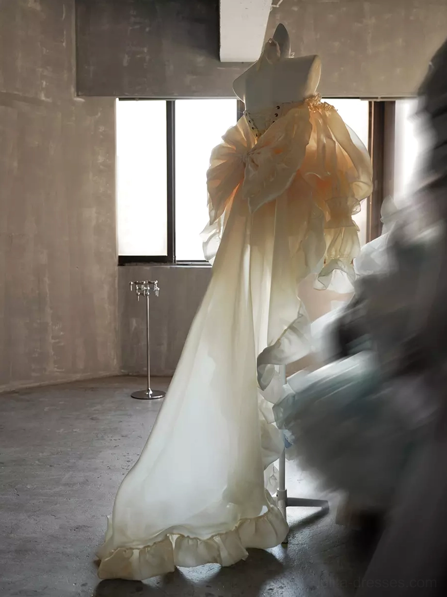 Champagne lolita dress back detail with ruffled train, layered skirt construction, bow placement, and theatrical rococo elements