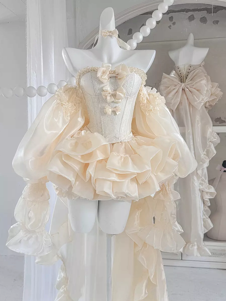 Strapless champagne lolita dress with oversized ruffled sleeves, corset bust detail, and sweeping floor-length trained skirt, front three-quarter studio view