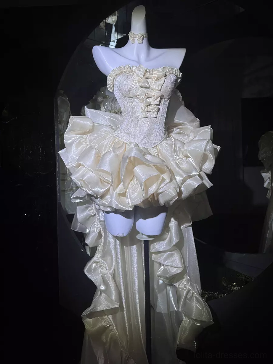 Short ruffled champagne lolita dress with strapless bow-adorned bust, layered long back train, and rococo details on dress form