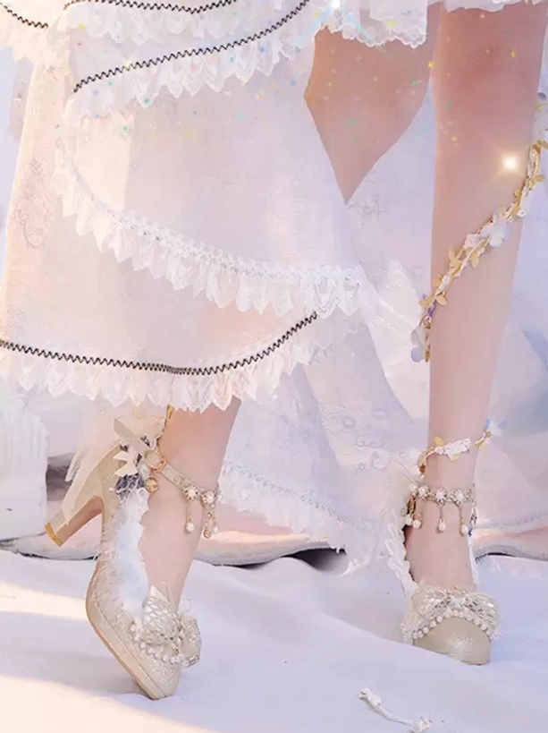 Side leg view of champagne lolita high heels with pearl ankle straps, front bow trim, feather accents, chunky heel worn with white frilly lolita skirt