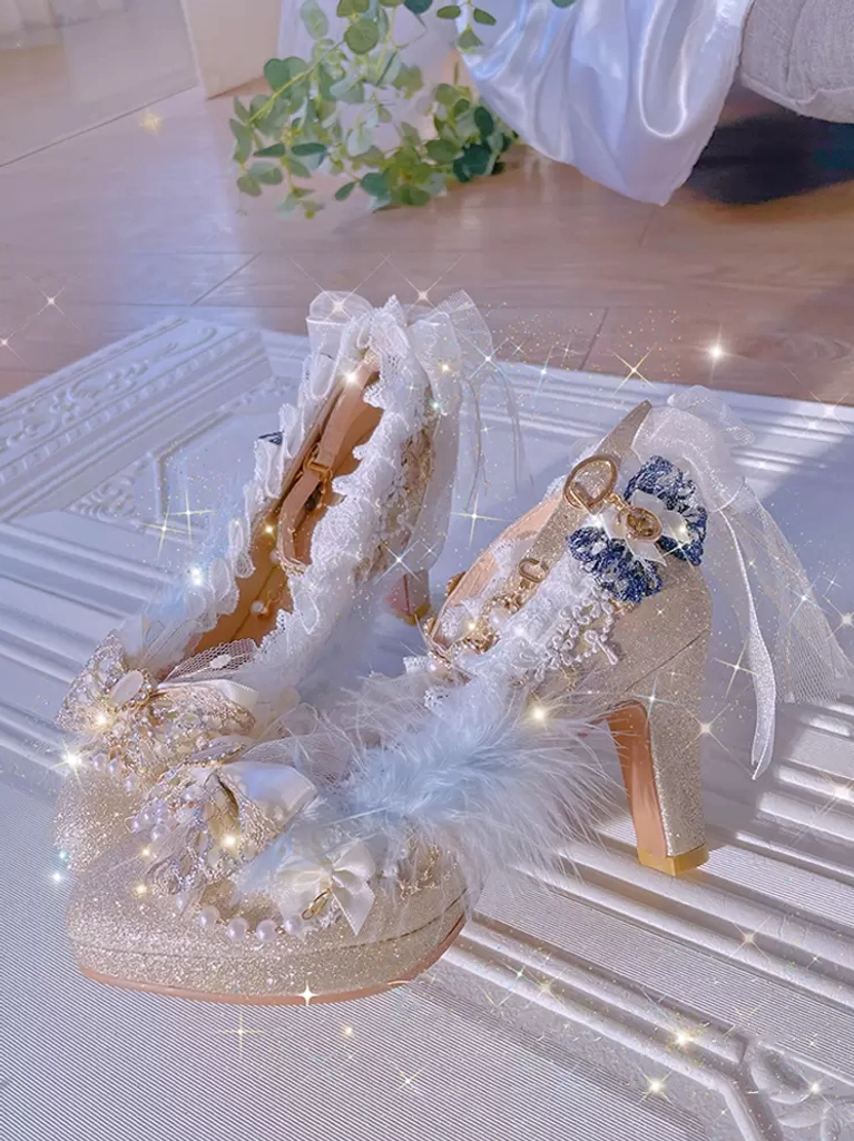 Angled flat lay of champagne glitter lolita footwear displaying blue bows, fluffy feather accents, lace ruffles, and pearl embellishments