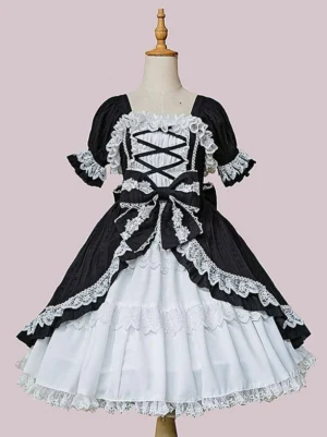 Classic black and white lolita dress with lace-up corset front closure displayed on mannequin, featuring white lace trim, front bow detail, and sleeveless design against pink background