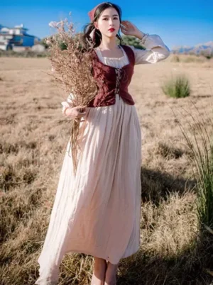 Classic Lolita burgundy corset victorian two-piece maxi dress front view with puff sleeves and cream pleated skirt on model in pastoral setting