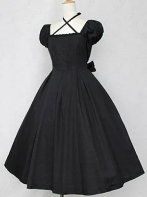 Classic Lolita cotton OP dress pure black color front view displaying structured pleated bodice puff sleeves cross halter design and Victorian-inspired silhouette